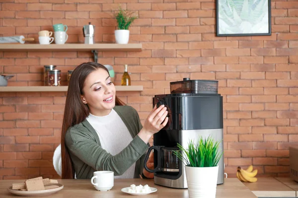 Mooie vrouw met koffiemachine in de keuken — Stockfoto