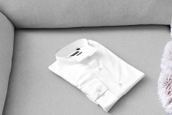 Folded shirt after dry-cleaning on sofa