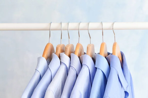 Rack with clothes after dry-cleaning on light background, closeup — Stock Photo, Image