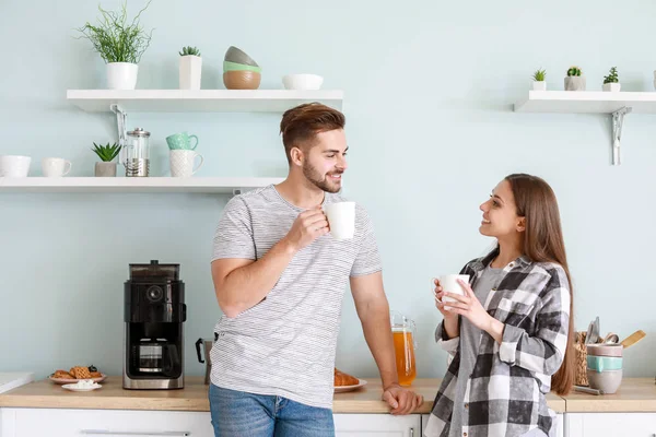 Young couple drinking hot coffee in kitchen — Stock Photo, Image