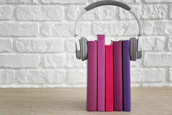 Książki i nowoczesne słuchawki na stole. Koncepcja audiobooka — Zdjęcie stockowe