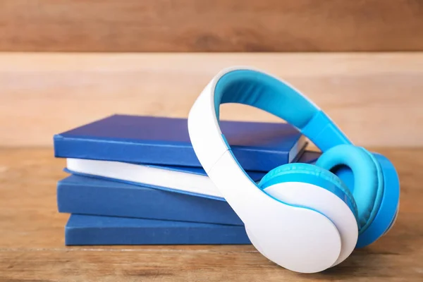 Bücher und moderne Kopfhörer auf dem Tisch. Hörbuchkonzept — Stockfoto