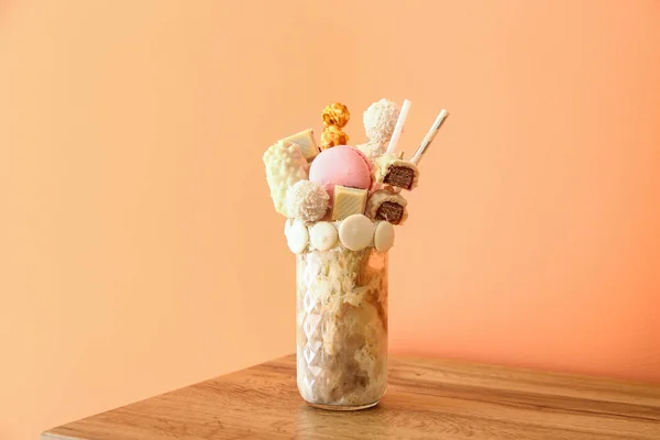 Delicious freak shake on table against color background — Stock Photo, Image