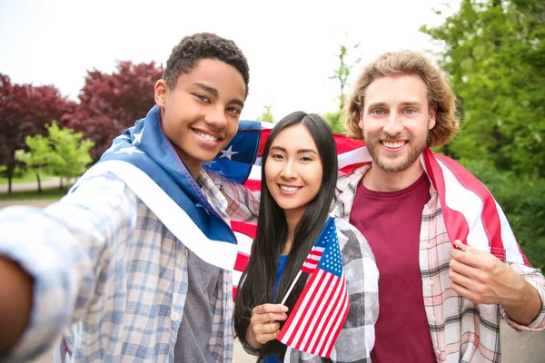 Groupe d'étudiants avec drapeau américain prenant selfie à l'extérieur — Photo