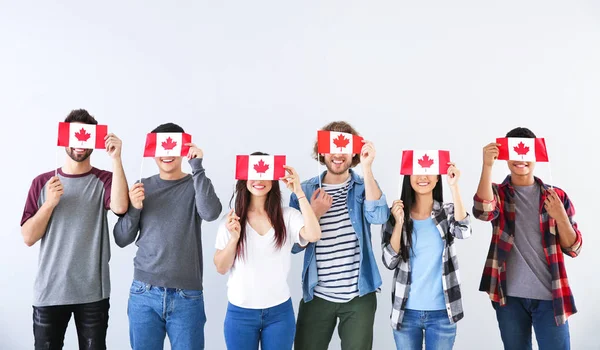 Gruppo di studenti con bandiere canadesi su sfondo chiaro — Foto Stock