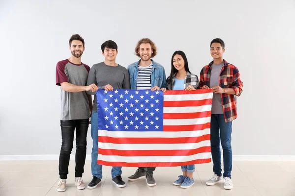 Diákok csoportja az USA zászló közelében világos fal — Stock Fotó