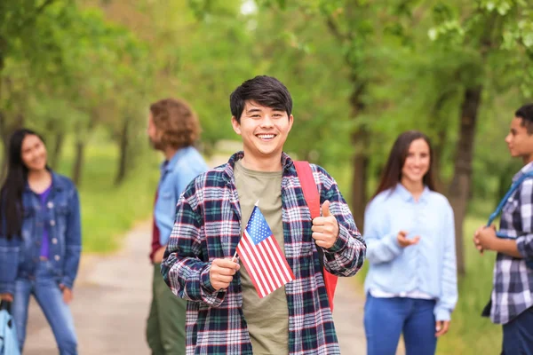 Estudiante asiático con bandera de Estados Unidos al aire libre — Foto de Stock