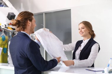 Modern kuru temizlemeciden kıyafet alan adam