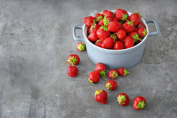 Topf mit reifen roten Erdbeeren auf grauem Hintergrund — Stockfoto