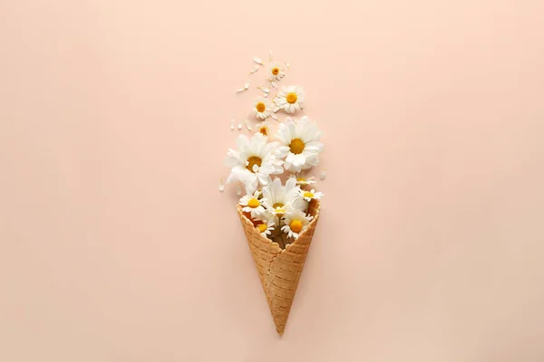 Composition with waffle cone and beautiful flowers on color background — Stock Photo, Image