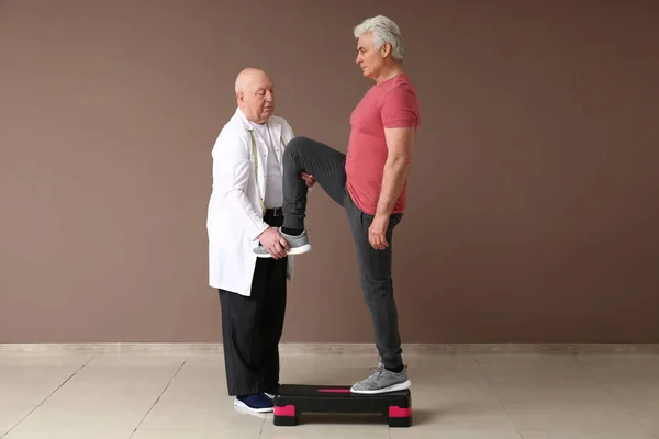 Senior physiotherapist working with mature man in clinic — Stock Photo, Image