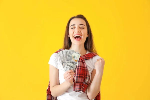 Happy young woman with dollar banknotes on color background — Stock Photo, Image