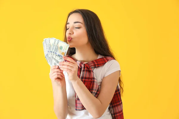 Happy young woman with dollar banknotes on color background — Stock Photo, Image
