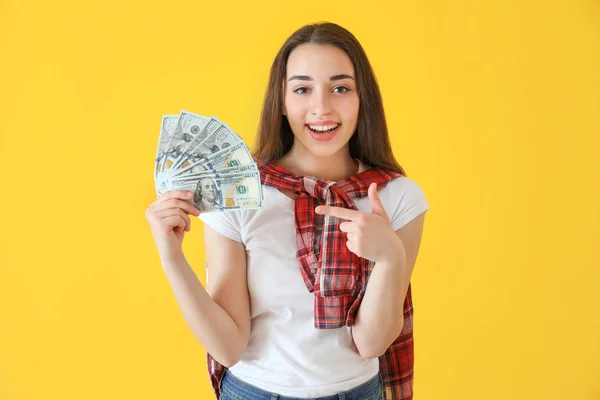 Mujer joven feliz con billetes de dólar en el fondo de color —  Fotos de Stock