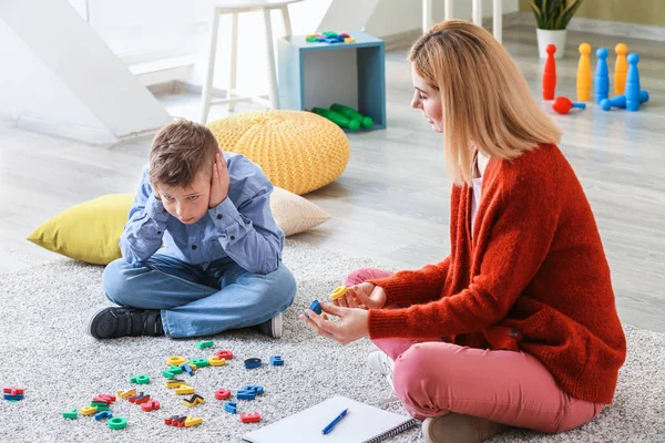 Female psychologist working with boy suffering from autistic disorder — Stock Photo, Image