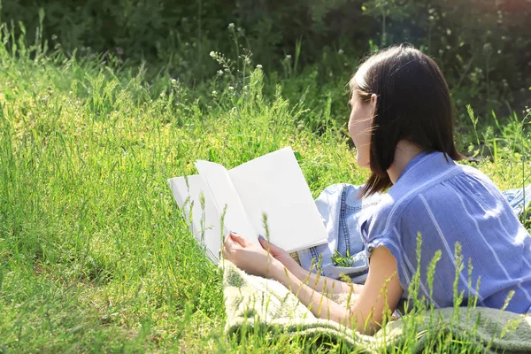 Piękna młoda kobieta czyta książkę w parku — Zdjęcie stockowe