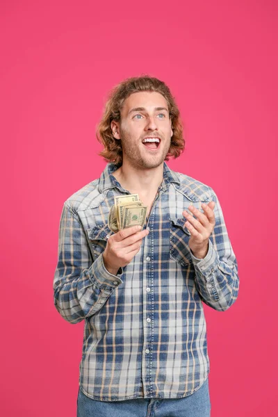 Красивый мужчина с деньгами на цветном фоне — стоковое фото