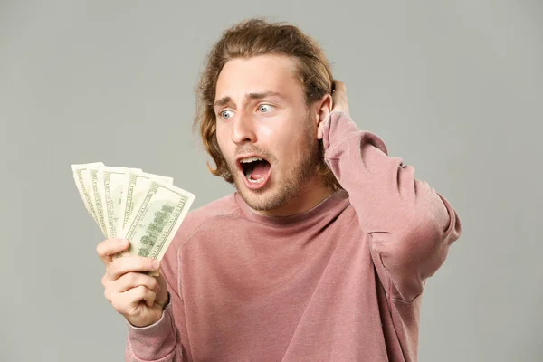 Hombre feliz con dinero sobre fondo gris — Foto de Stock