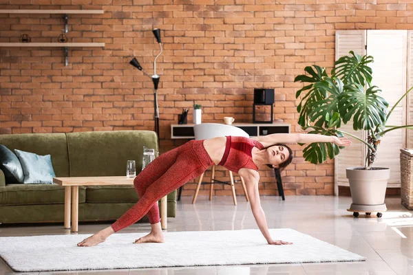 Young woman practicing yoga at home — Stock Photo, Image