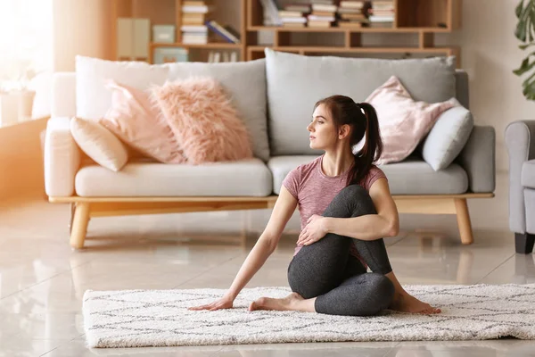 Young woman practicing yoga at home — Stock Photo, Image