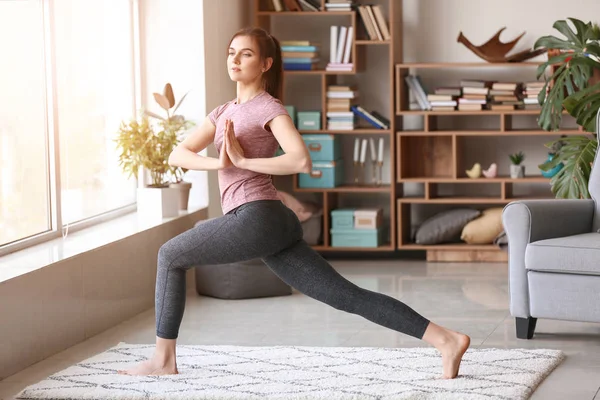 Jonge vrouw die thuis yoga oefent — Stockfoto