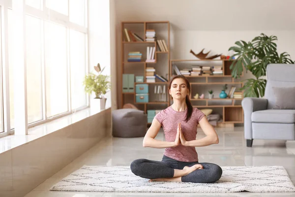 Young woman practicing yoga at home — Stock Photo, Image