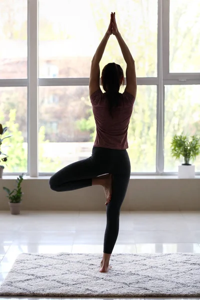 Silhuett av ung kvinna praktiserande yoga hemma — Stockfoto