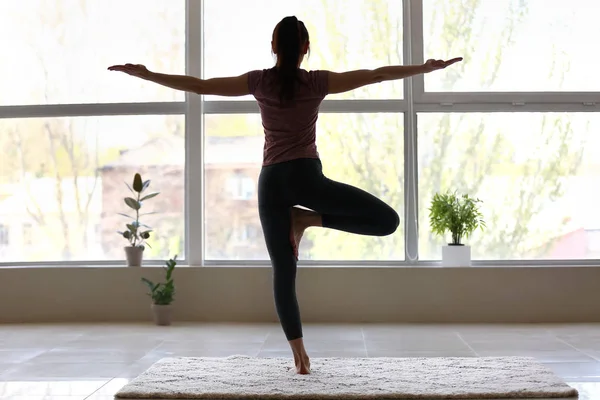 Silhuett av ung kvinna praktiserande yoga hemma — Stockfoto