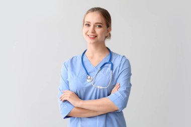 Gri arka planda genç tıbbi asistan