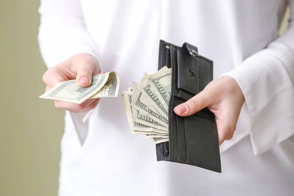 Jovem segurando carteira com notas de dólar, close-up — Fotografia de Stock