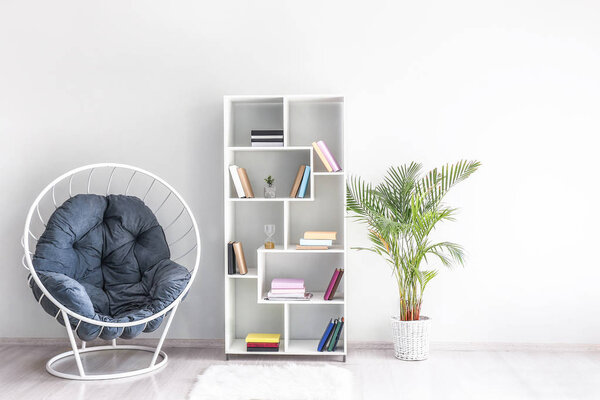 Armchair and shelf unit near light wall