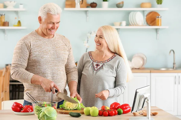 Portrait of happy mature couple cooking in kitchen — Stock Photo, Image