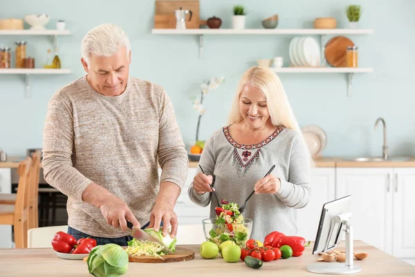 Portrait of happy mature couple cooking in kitchen — Stock Photo, Image