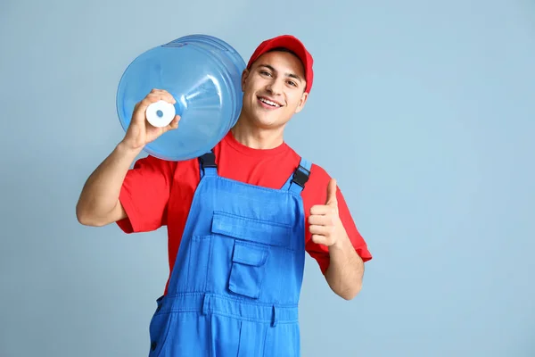 Delivery man with bottle of water on color background — Stock Photo, Image