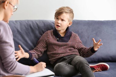 Ofiste küçük bir çocukla çalışan kadın psikolog