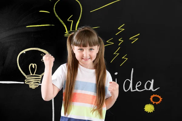 Little girl near drawn light bulbs on dark wall — Stock Photo, Image