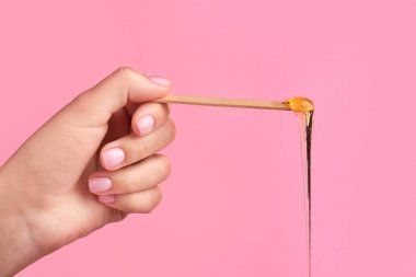 Renk arka plan karşı sopa üzerinde şekerleme hamuru ile Kadın el