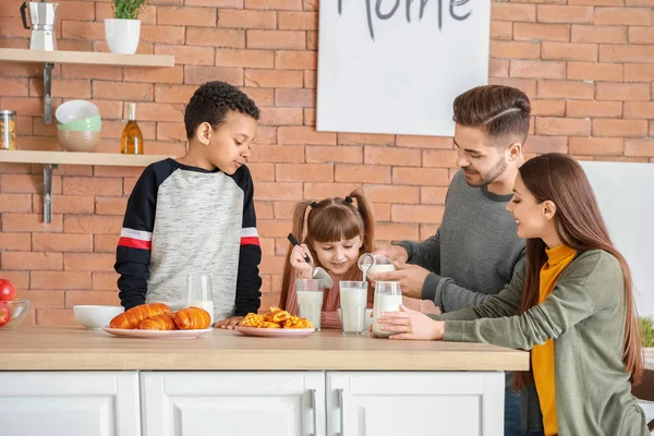 Mladá rodina pije chutné mléko v kuchyni doma — Stock fotografie
