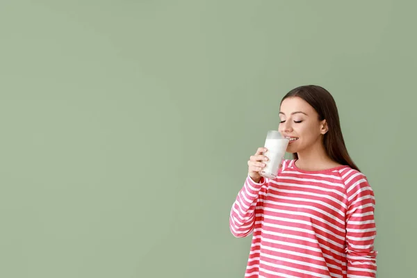 Beautiful woman drinking tasty milk on color background — Stock Photo, Image