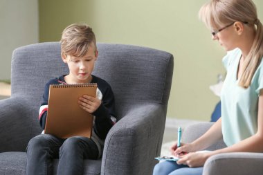 Ofiste küçük bir çocukla çalışan kadın psikolog