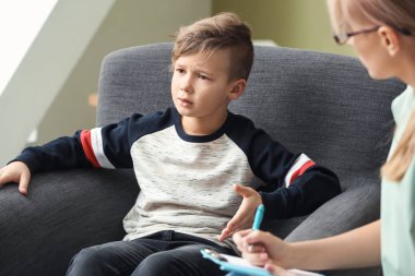 Ofiste küçük bir çocukla çalışan kadın psikolog