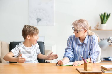 Kadın psikolog ofiste yaramaz küçük çocuk ile çalışıyor