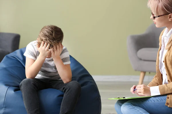 Psicóloga mujer trabajando con un niño triste en la oficina —  Fotos de Stock