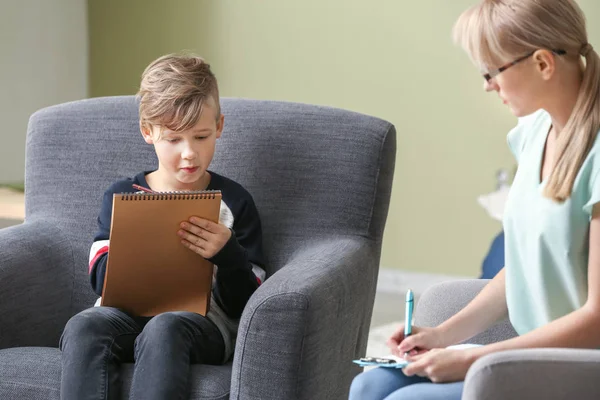 Ofiste küçük bir çocukla çalışan kadın psikolog