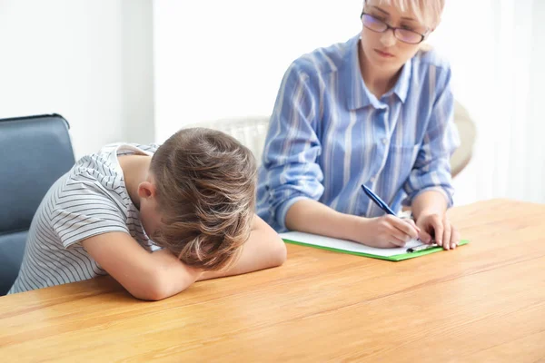 Psicóloga femenina trabajando con un niño travieso en la oficina — Foto de Stock