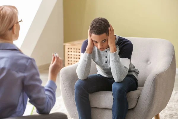 Female psychologist working with depressed teenage boy in office — Stock Photo, Image