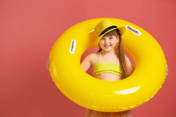 Schattig klein meisje met opblaasbare ring op kleur achtergrond — Stockfoto