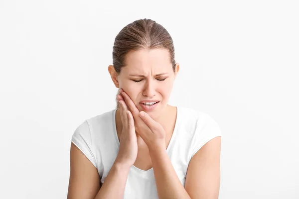 Young woman suffering from toothache on white background — Stock Photo, Image