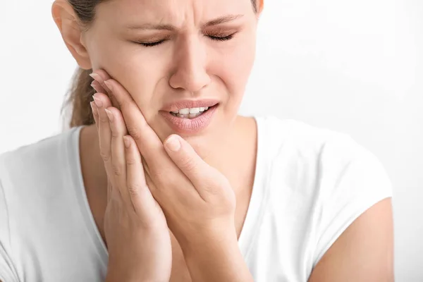 Jovem que sofre de dor de dente no fundo branco — Fotografia de Stock