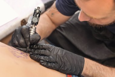Profesyonel sanatçı kuaförde dövme yapıyor.